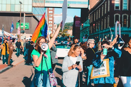 A vibrant protest with diverse participants holding flags and signs on a city street.